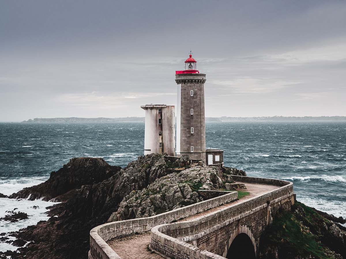 ocean white and red lighthouse near body of water tower