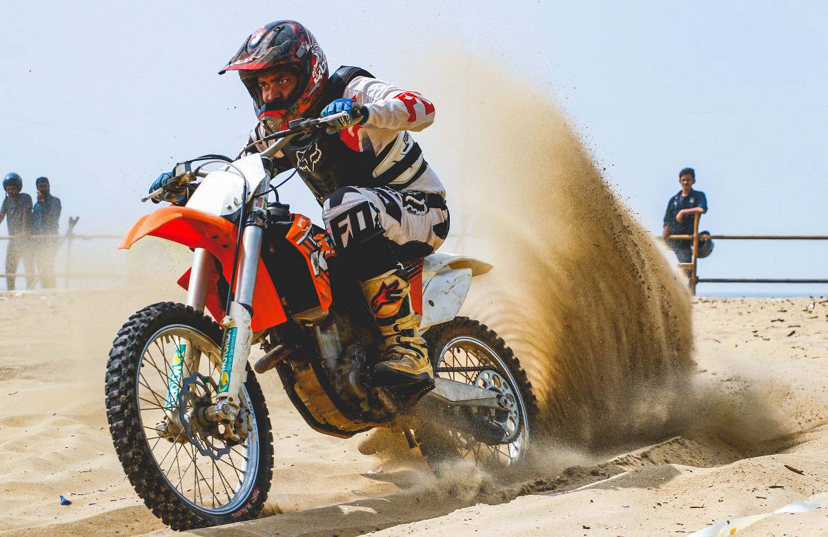 motocross man on sand dunes riding motorcycle biker
