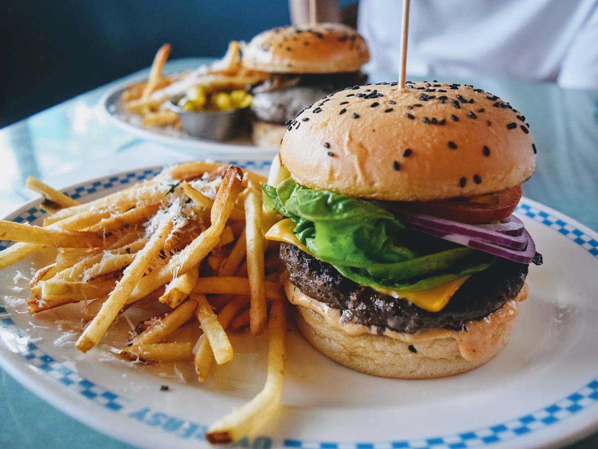 burger burger with lettuce and tomato on white ceramic plate fries