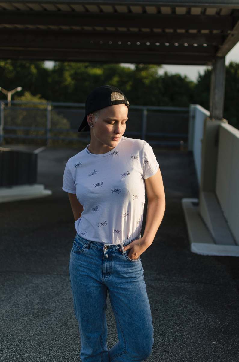 bremen woman in white shirt standing near white rail jeans