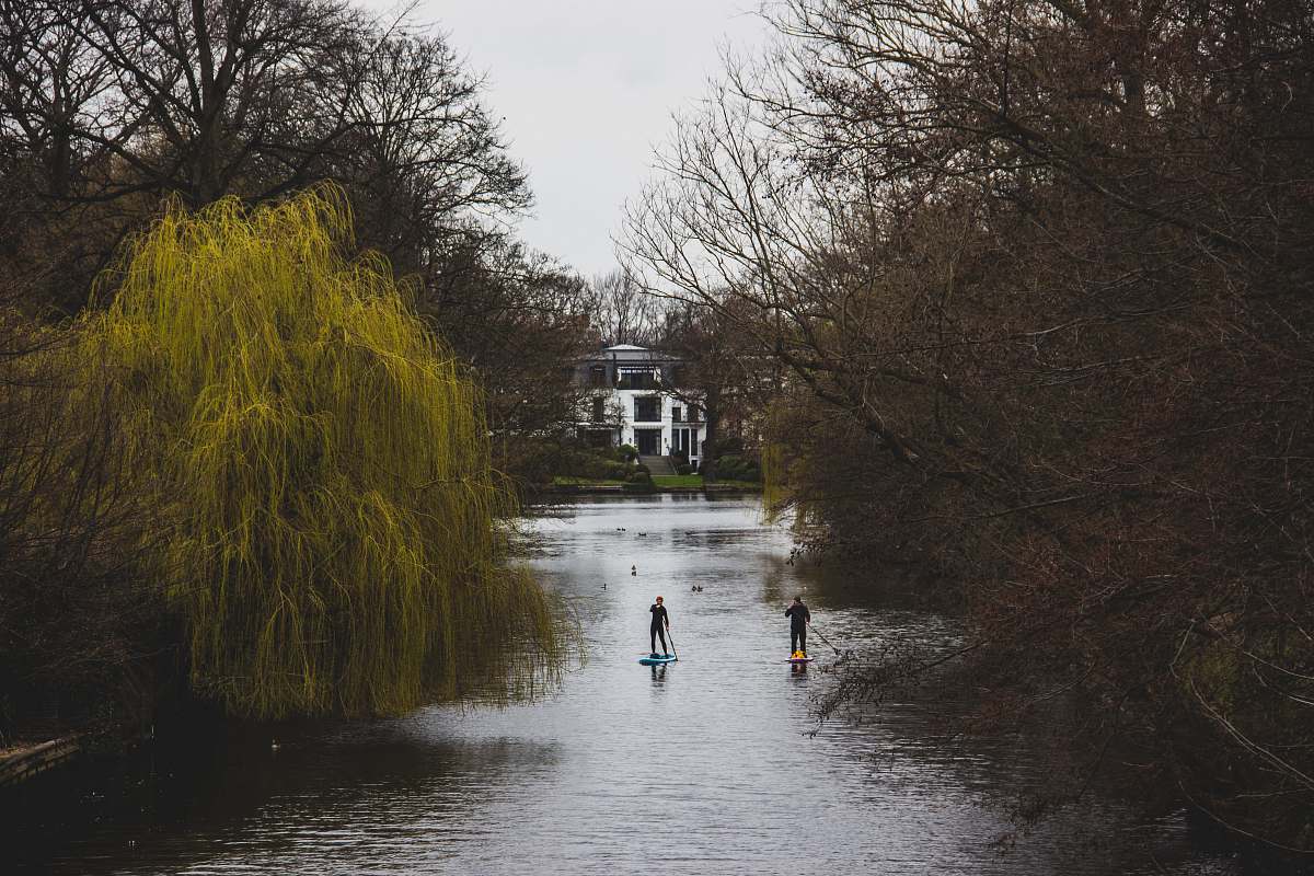 hamburg 2 person walking on river between trees during daytime nature