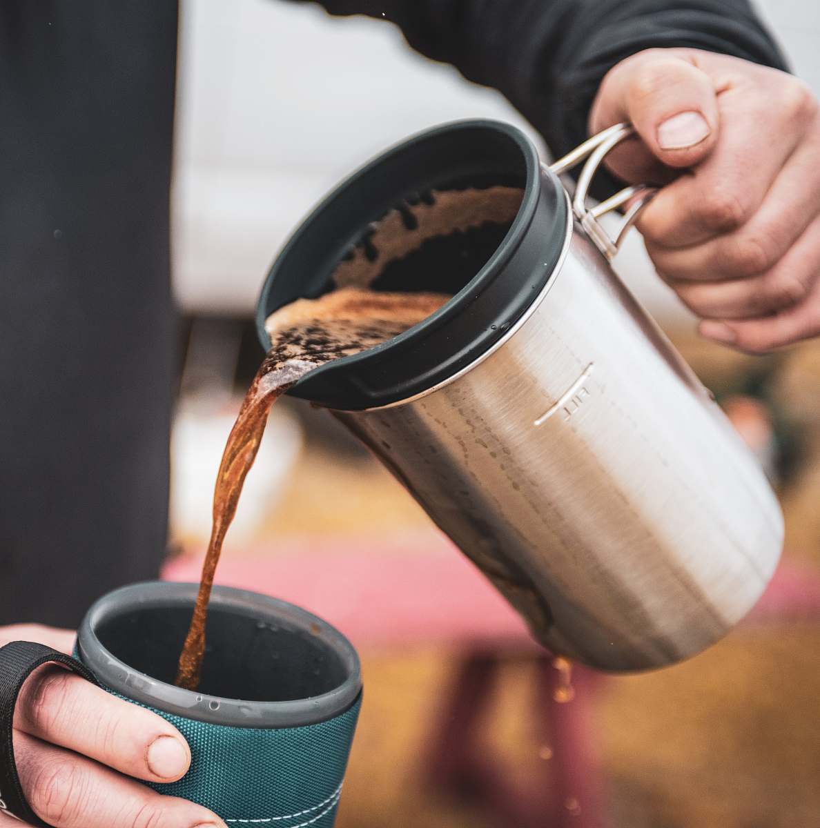  person pouring water on silver steel cup 