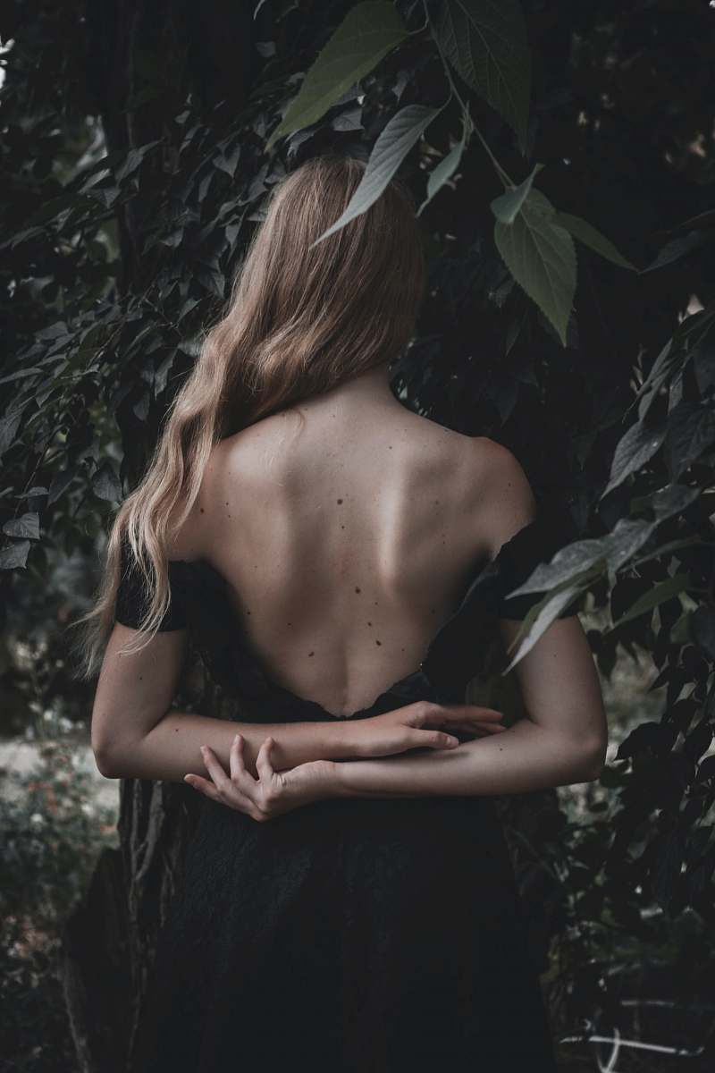  woman wearing backless dress near leaves 