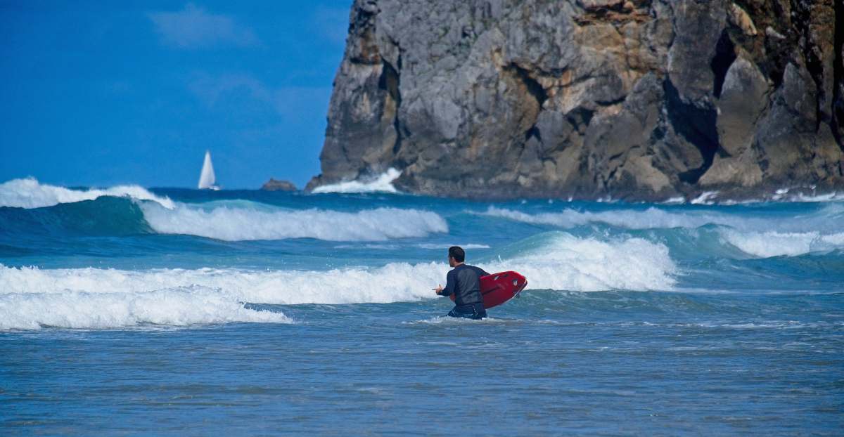water man in red surfing board on sea during daytime ocean