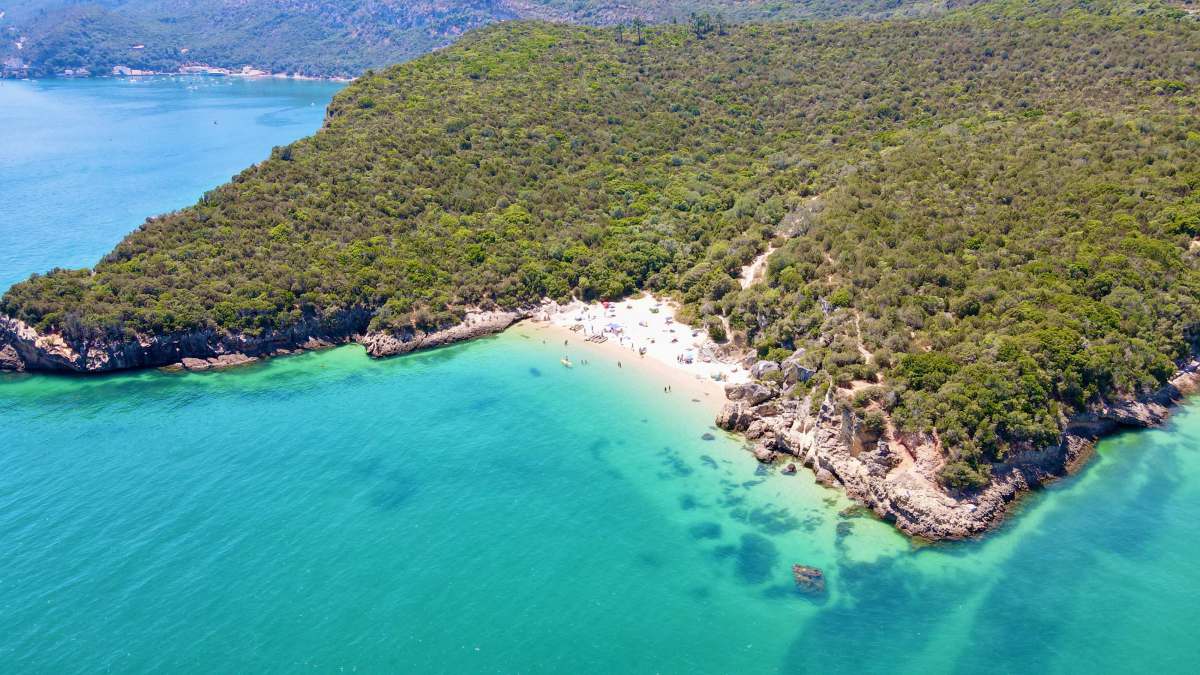beach aerial view of green and brown mountain beside body of water during daytime  lisbon