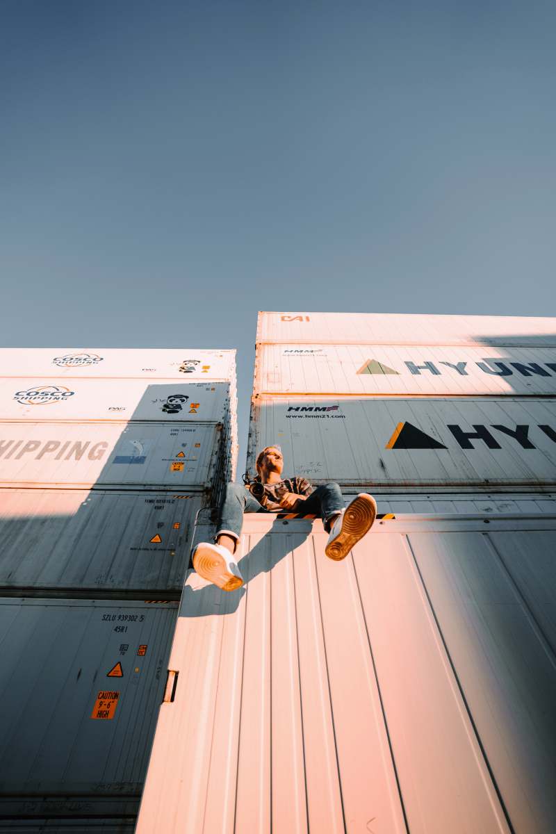 youth man in black t-shirt and brown pants sitting on white and blue box port