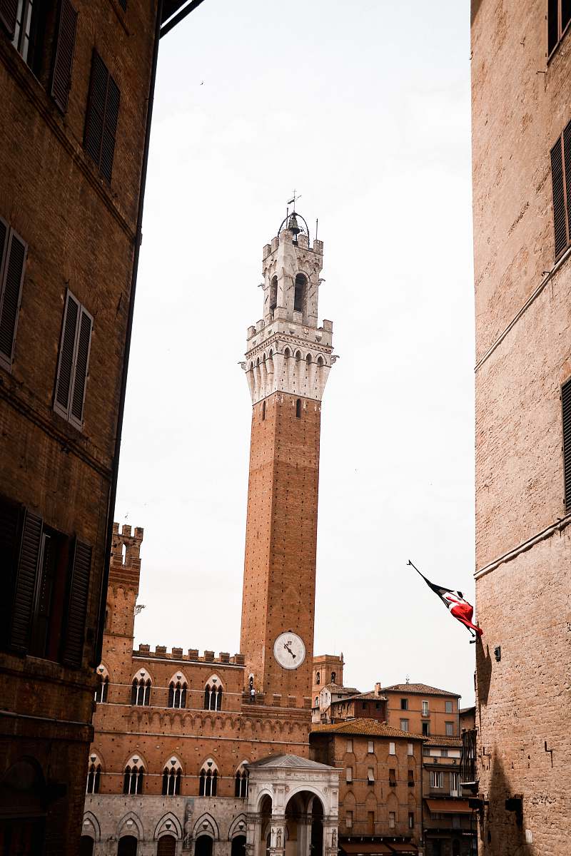 building brown concrete tower with red flag on top tower