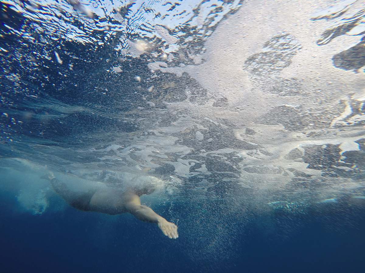 sea person diving under water grey