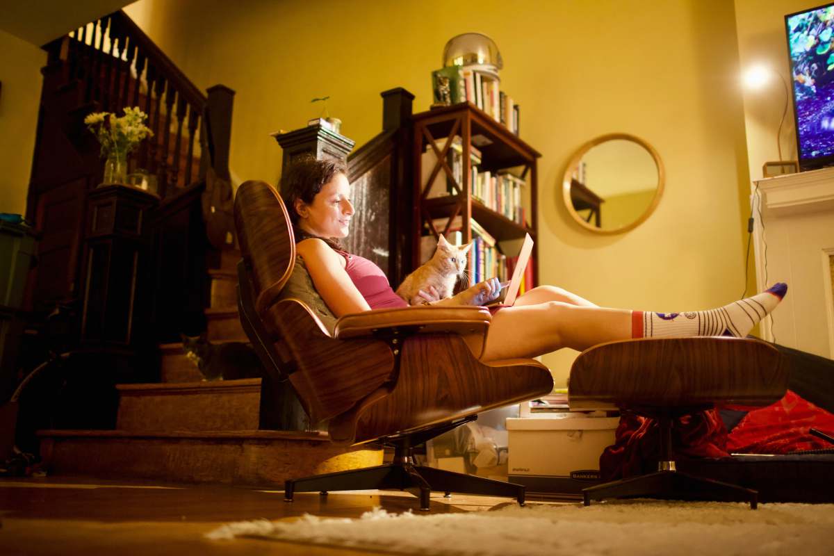 writing woman in white shirt sitting on brown wooden armchair work from home