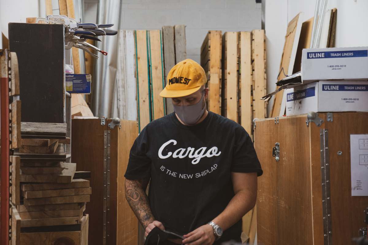masks man in black crew neck t-shirt and yellow cap holding black smartphone covid19