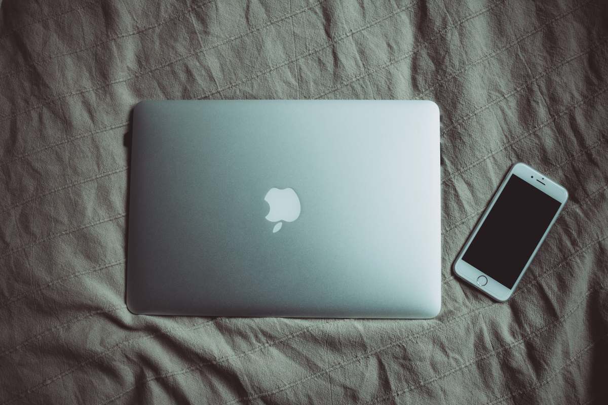  silver MacBook beside post-2014 iPhone 