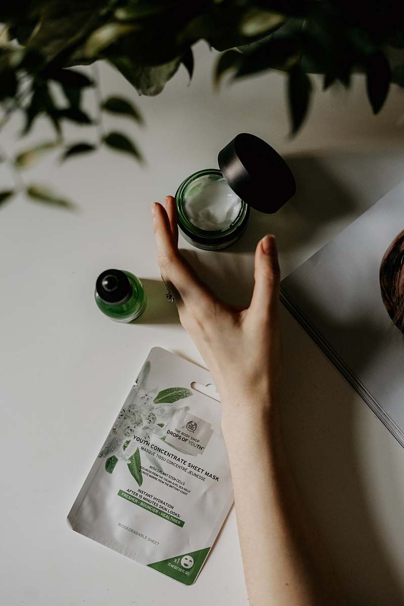 skincare person touching black plastic bottle facial