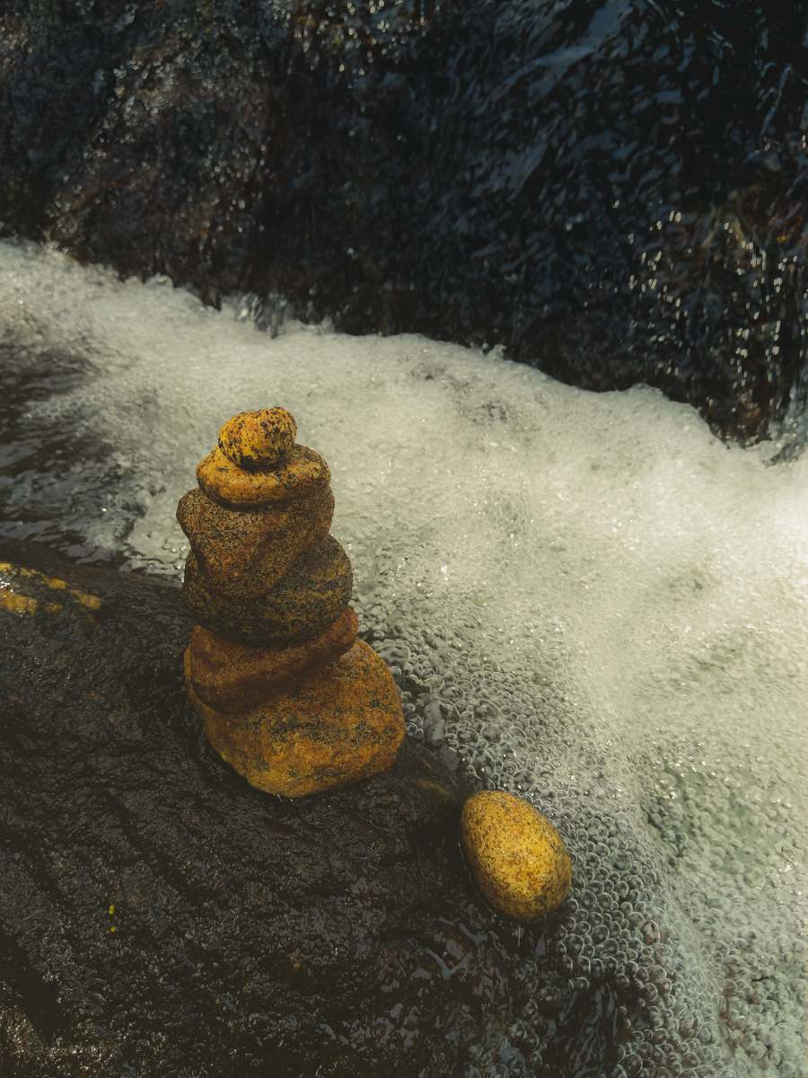 peaceful brown rock formation on water river bank