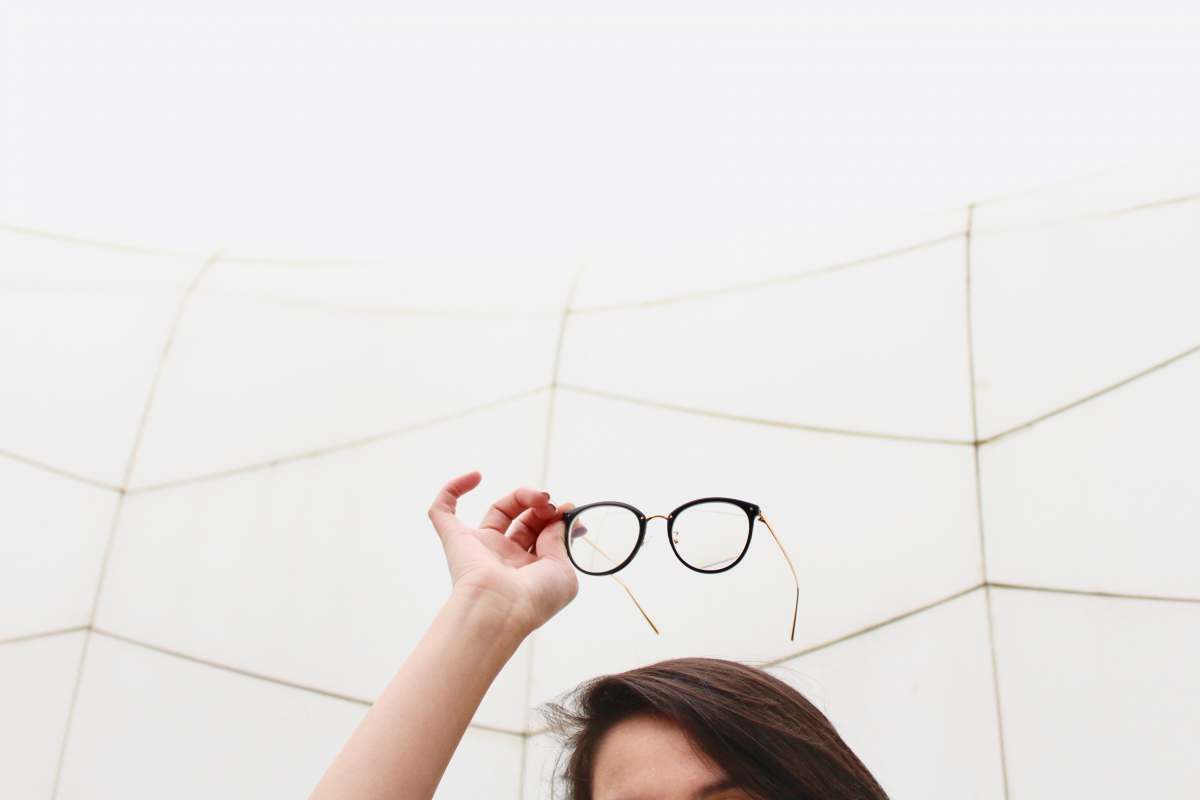  person holding black framed eyeglasses 