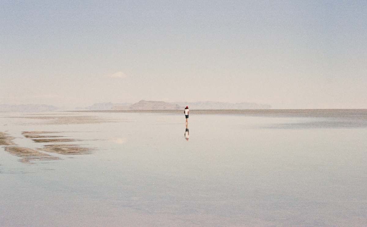  person in white shirt walking on beach during daytime 