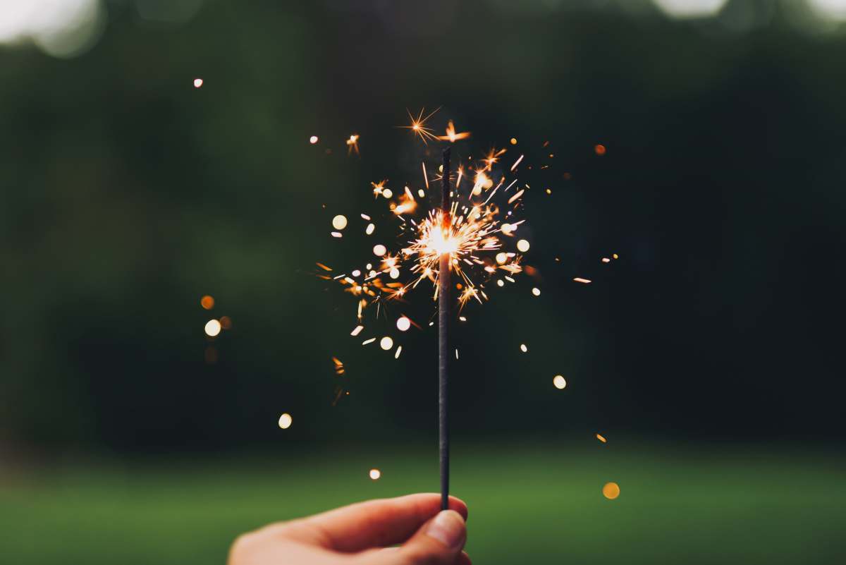  person holding sparkler with bokeh effect 