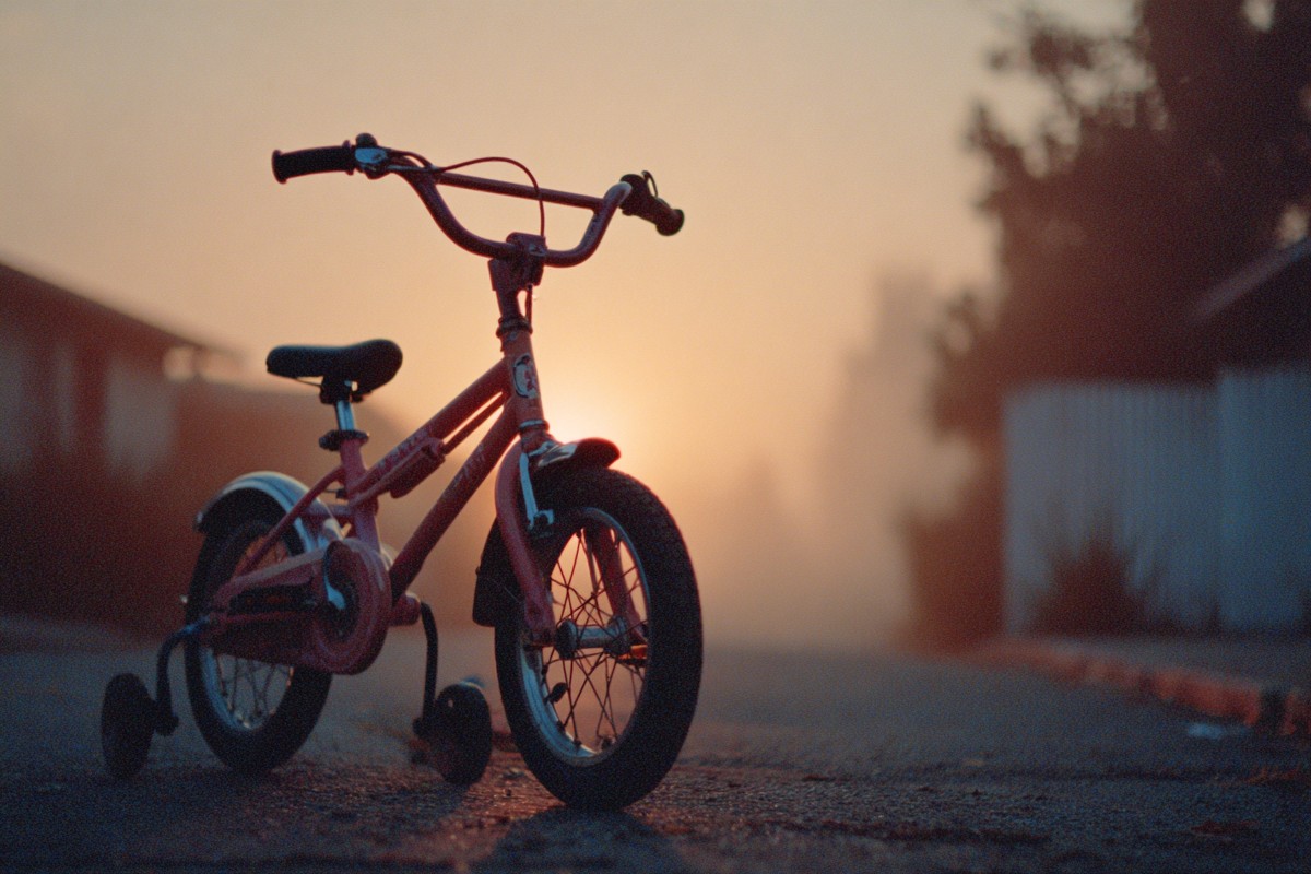 bike with training wheels parked sunset film 2f669e08 3239 431d