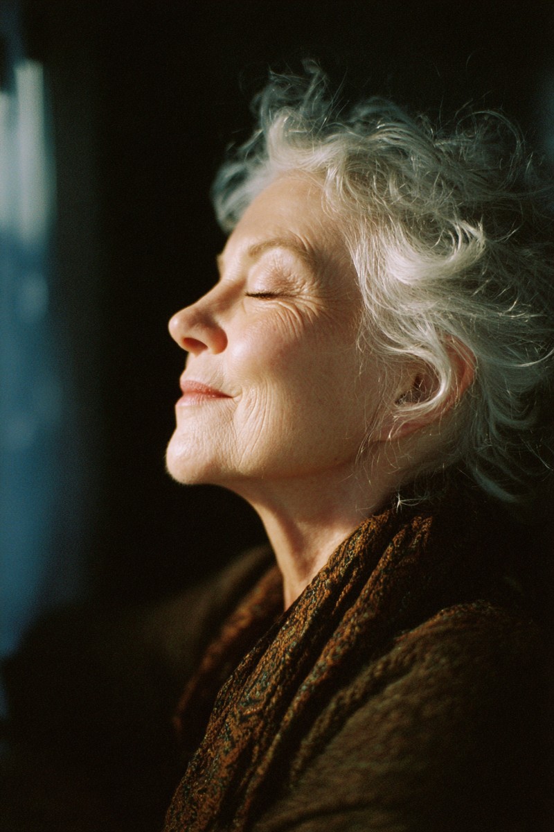 hopeful light older woman closing her eyes and smi 720d2b4a