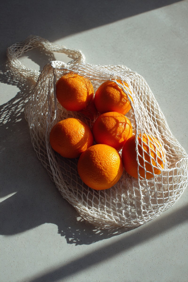 white mesh bag containing oranges placed d1c3d9bb 4238 40c7 8cea