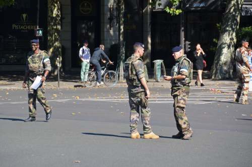 military men in green and brown camouflage uniform walking on street during daytime show