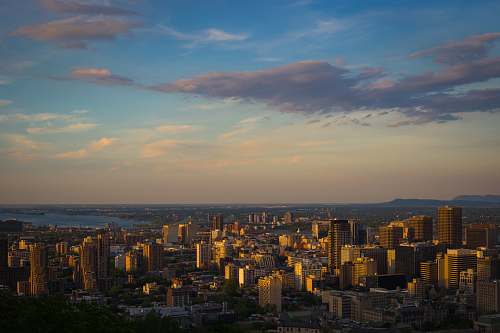 nature aerial photography of city with high-rise buildings viewing blue sea under blue and white sky during daytime landscape
