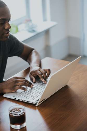 human man in gray crew neck t-shirt using laptop person