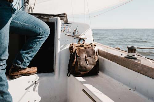 boat person in blue denim jeans on yacht beside brown bag norfolk