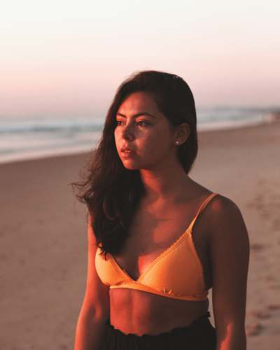 bikini woman in orange bikini top standing on beach during daytime surfers paradise qld