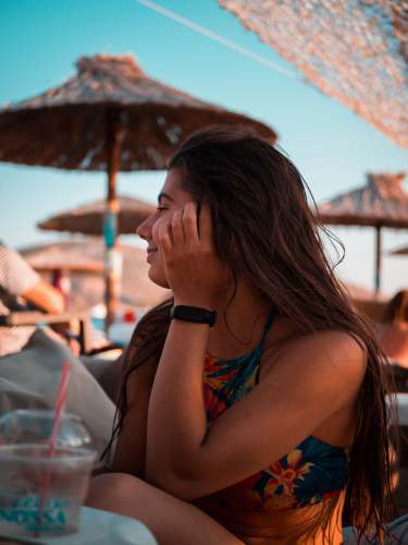 greece woman in blue and red floral tank top covering her face with her hand anavyssos