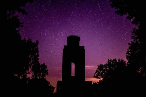 bismarckturm silhouette of man standing on the edge of building during night time byhleguhrer straße