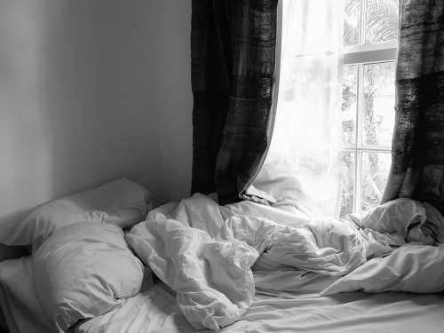 bedroom grayscale photo of bed with white blanket bedding