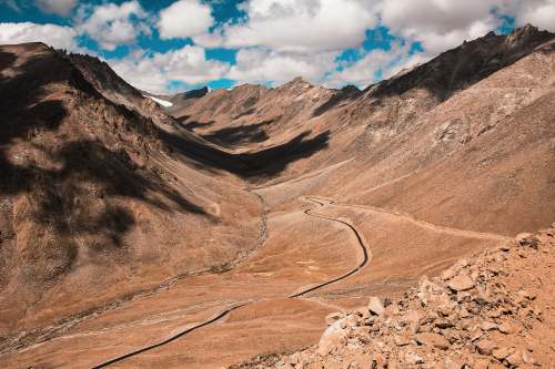 mountain brown rocky mountain under blue sky during daytime road