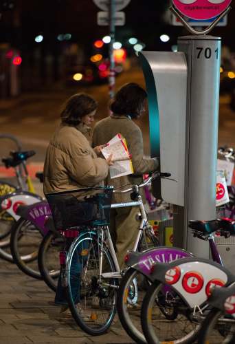 austria woman in brown jacket standing beside bicycle city bike