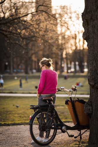 bonn woman in purple long sleeve shirt riding bicycle on road during daytime street photography