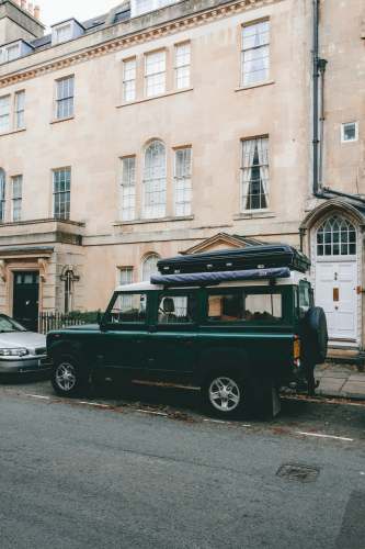 travel black suv parked beside beige concrete building during daytime england