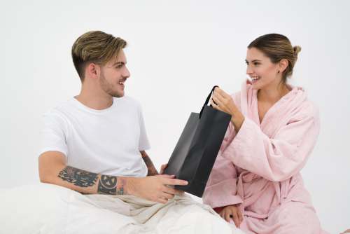fashion woman holding black paper bag sitting in front of the man couple