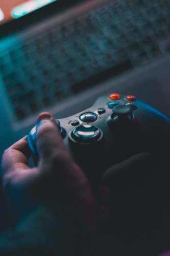 gaming person holding black game controller grey