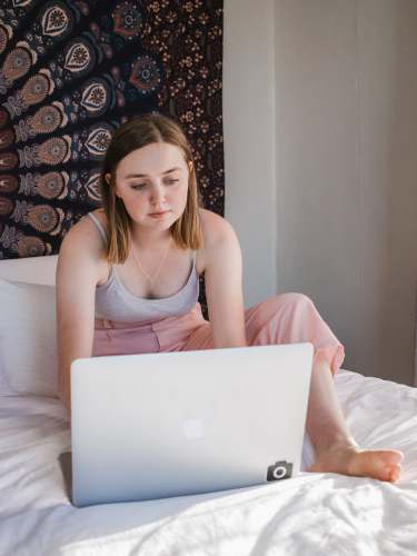 laptop woman sitting on bed and using laptop darling