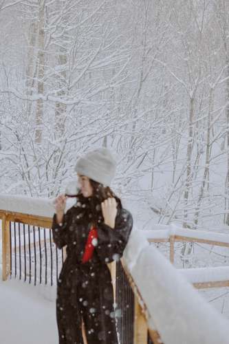 qc woman in black jacket and white knit cap standing on snow covered ground during daytime canada