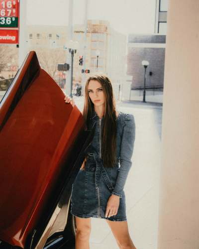 usa woman in blue denim jacket standing beside red car clothing