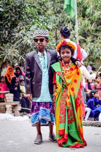 bangladesh man in green suit jacket and woman in green and yellow sari dress children