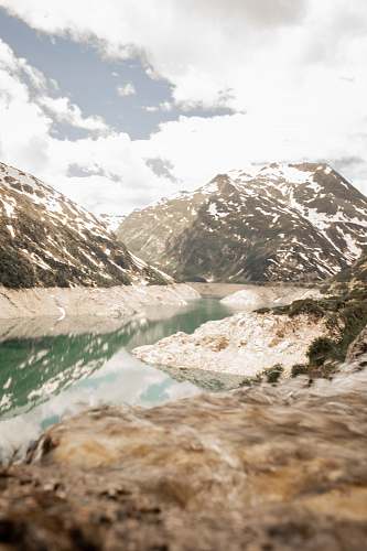 austria body of water near snow covered mountain during daytime mountains