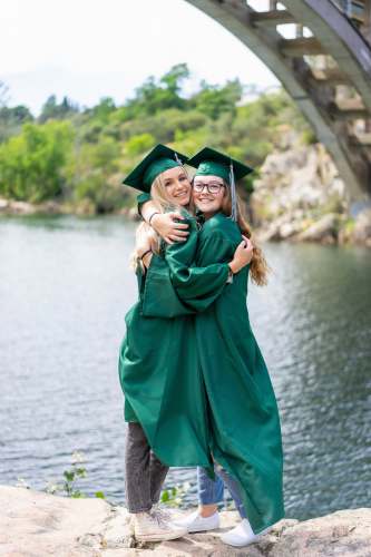 friendship woman in green academic dress standing on gray concrete pavement during daytime graduates
