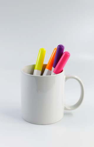 cup white ceramic mug with assorted color pencils marker