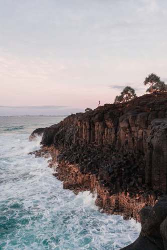  brown rocky mountain beside sea during daytime 