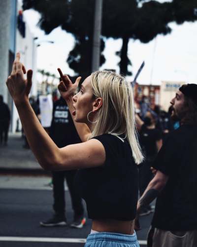  woman in black shirt standing on street during daytime 